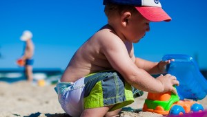 BOY PLAYING ON THE BEACH