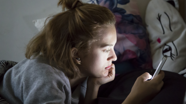 web2-teenage-girl-looks-on-her-smartphone-in-bed-during-the-night-shutterstock_547499824.png