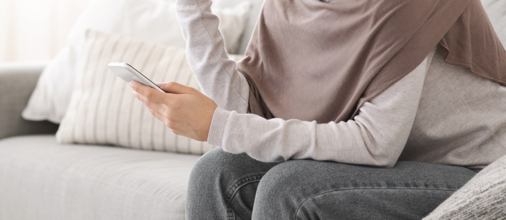 Muslim woman looking at phone