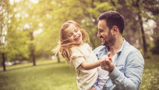 Father and daughter at park dancing and holding hands
