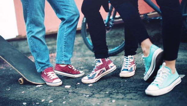 Close up of modern sneakers worn by friends