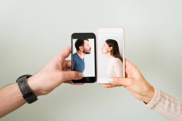 Close up of the hands of an attractive couple with smartphones and the photograph
