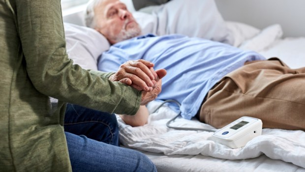 mature male patient at hospital with worried wife sitting with him