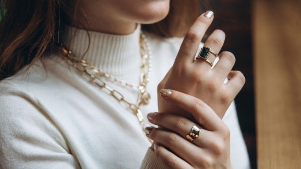 Woman's hands close up wearing rings and necklace