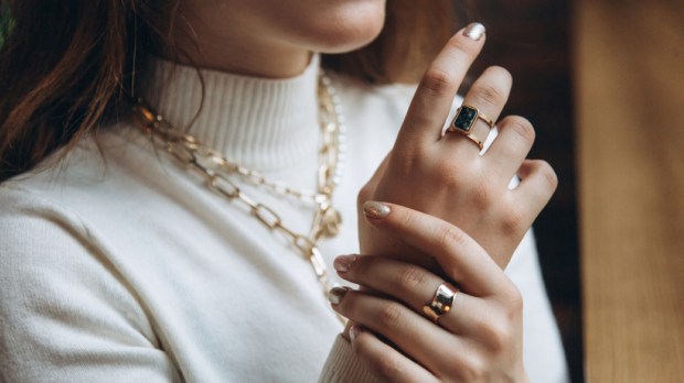Woman's hands close up wearing rings and necklace