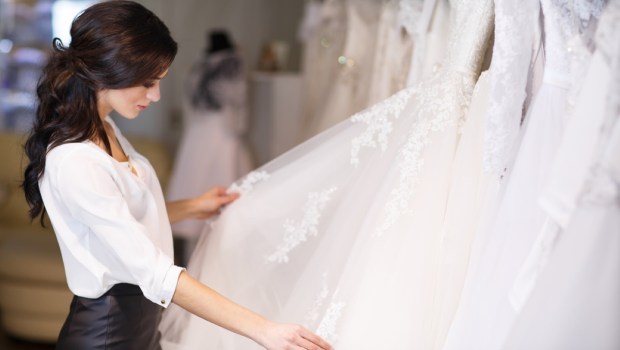 dealer consultant in the background of wedding dresses