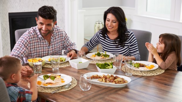 Hispanic Family Enjoying Meal At Table
