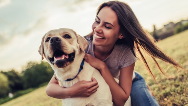 Attractive young woman with labrador outdoors
