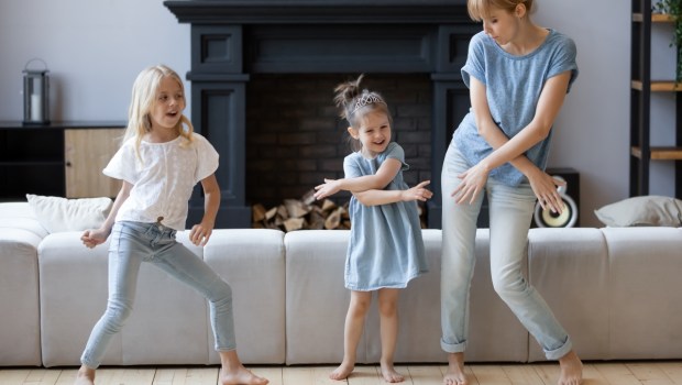 Happy mother dancing, having fun with two daughter