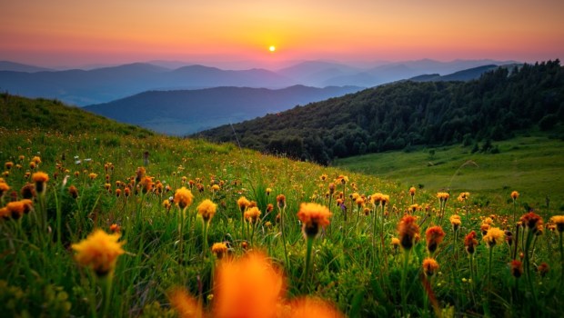 The sun sets behind the mountain ranges